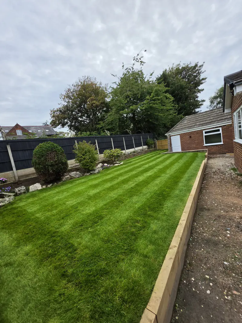 The same lawn freshly cut and striped after the maintenance visit